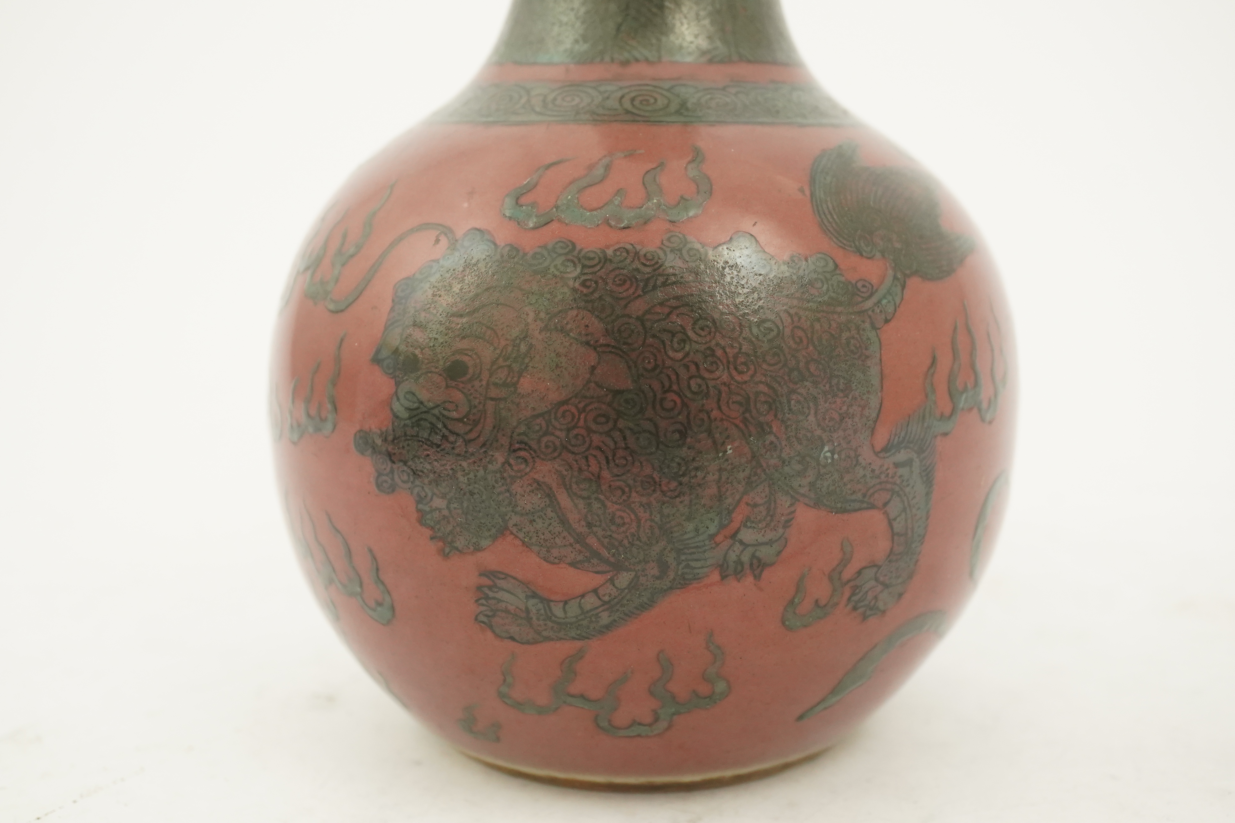 A Chinese green enamelled sang de boeuf ground 'lion' bottle vase, probably 18th century
